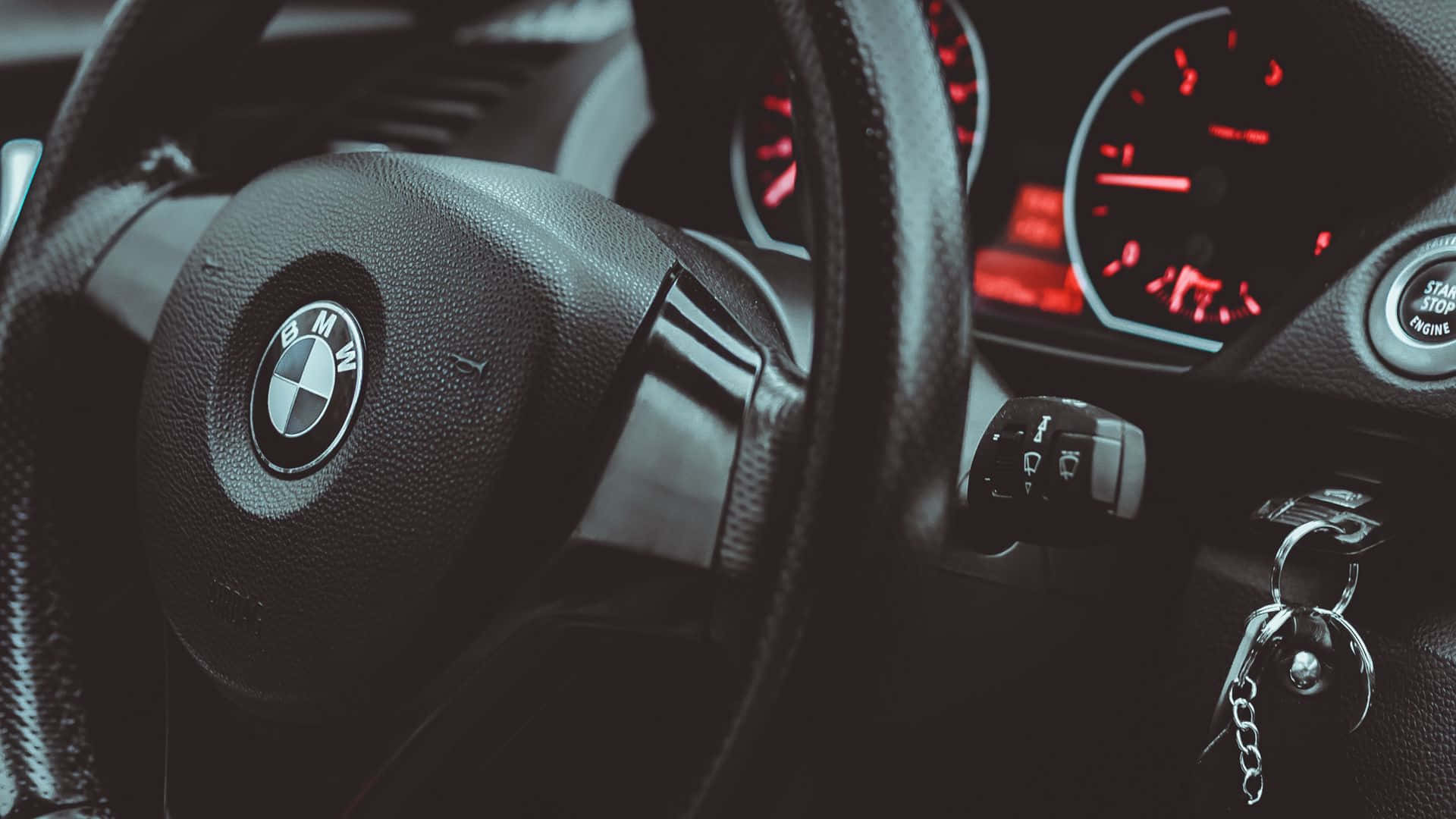 A Close-up Of A Black Luxurious Car Steering Wheel Wallpaper