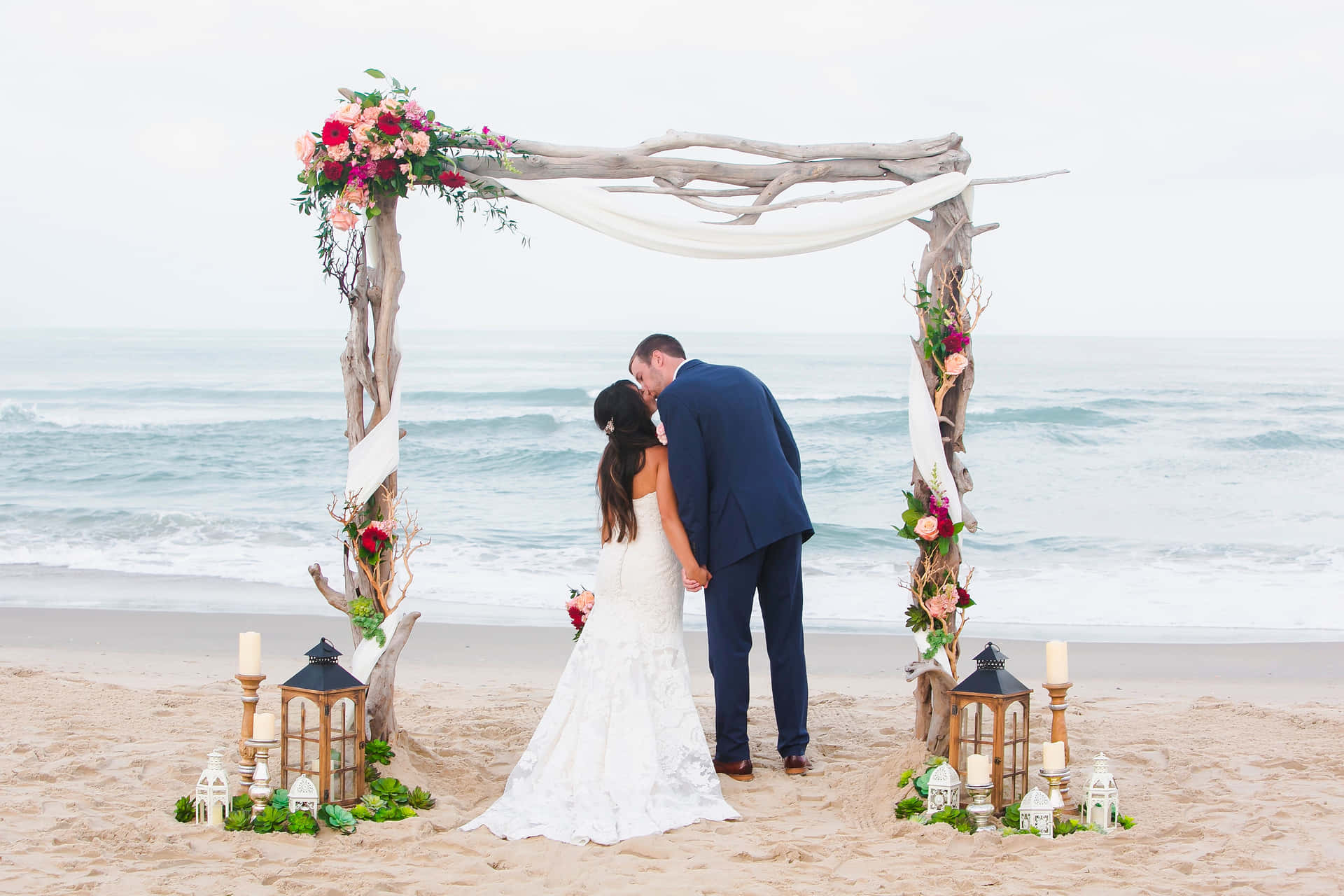 A Fairytale Moment - Loving Couple Exchanging Vows During A Stunning Beach Wedding. Wallpaper