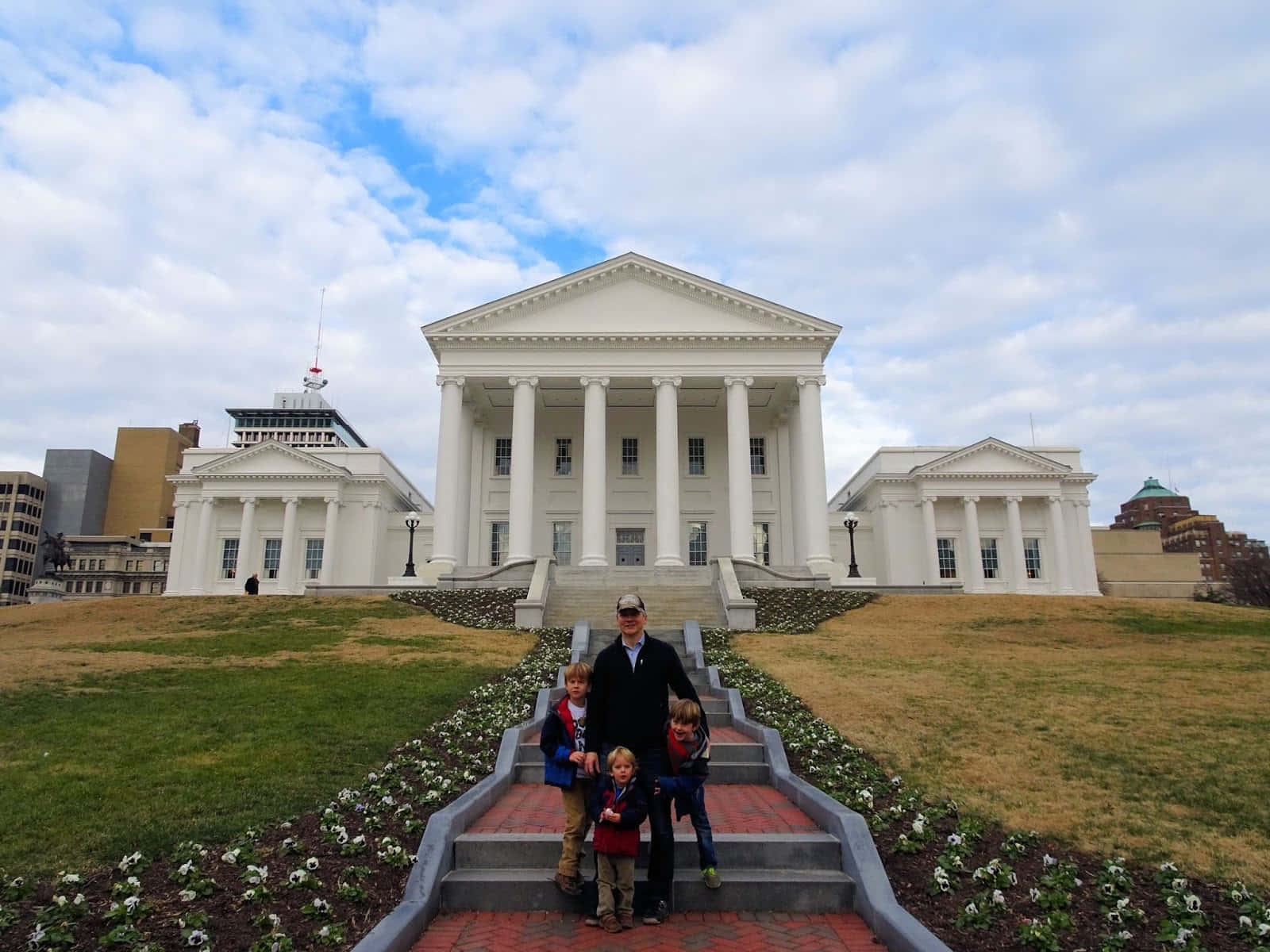 A Family Posing In Front Of The Virginia State Capitol Wallpaper