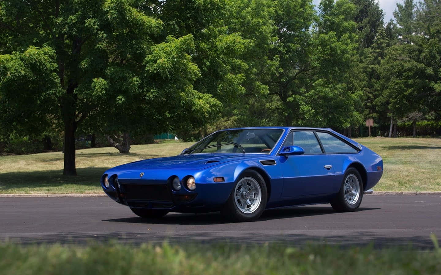 A Gleaming Lamborghini Jarama Showcased In Contrast With The Moody Sky Wallpaper