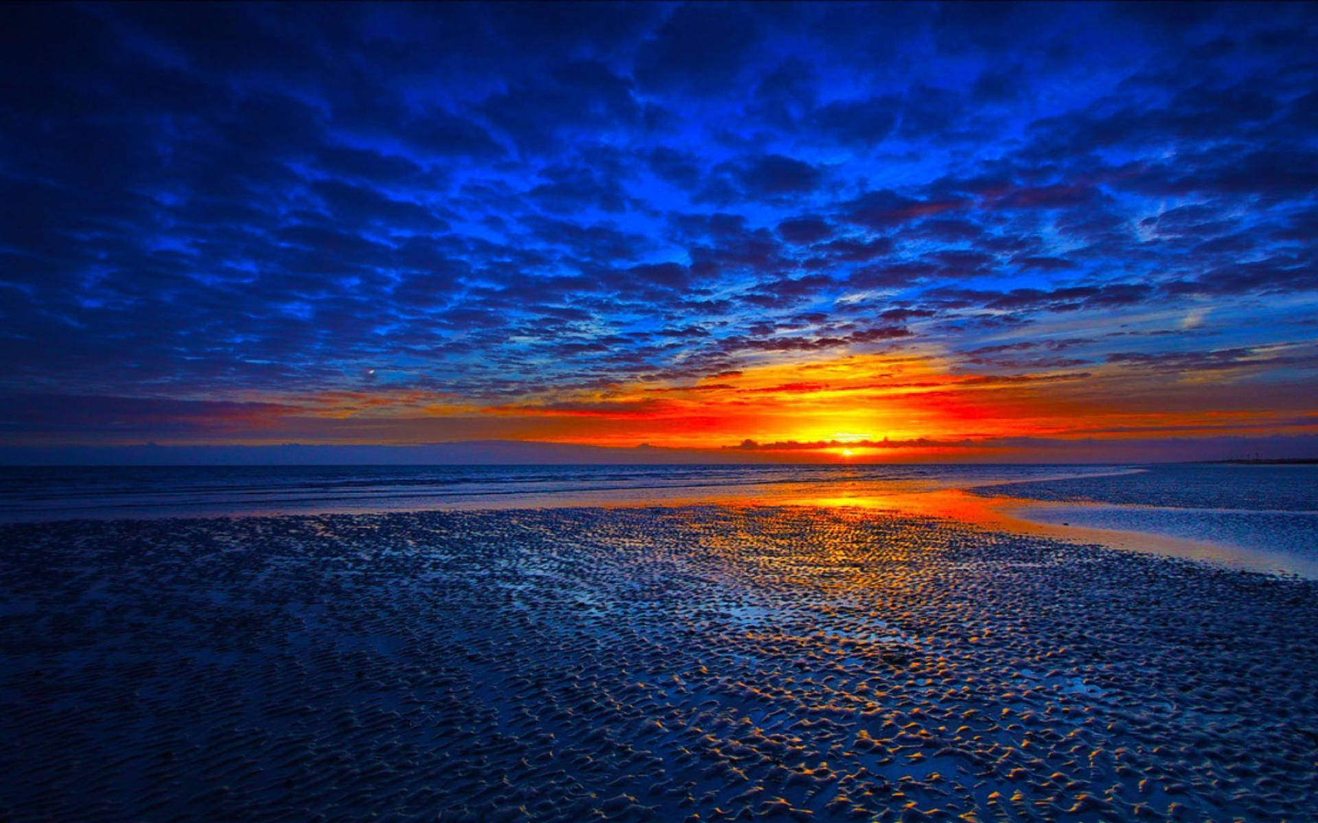 A Gorgeous Sunset Viewed From A Tropical Beach Wallpaper