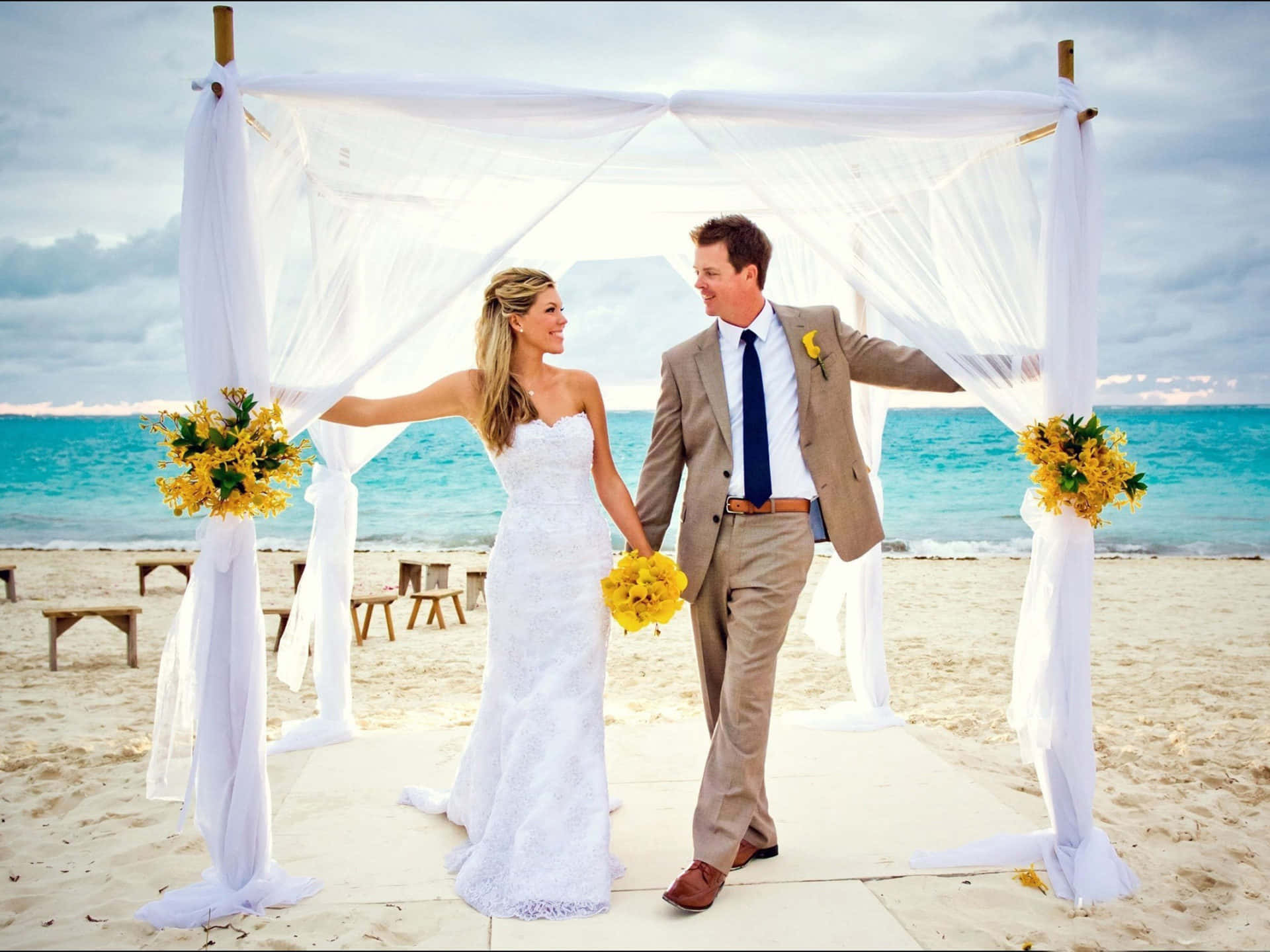 A Perfect Moment Captured - Newlywed Couple At A Beautiful Beach Wedding Wallpaper