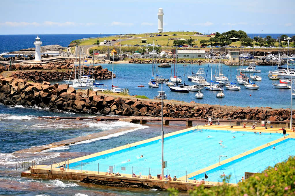 A Scenic View Of The Coastline Of Wollongong With The Lighthouse At The Center, During Sunset Wallpaper