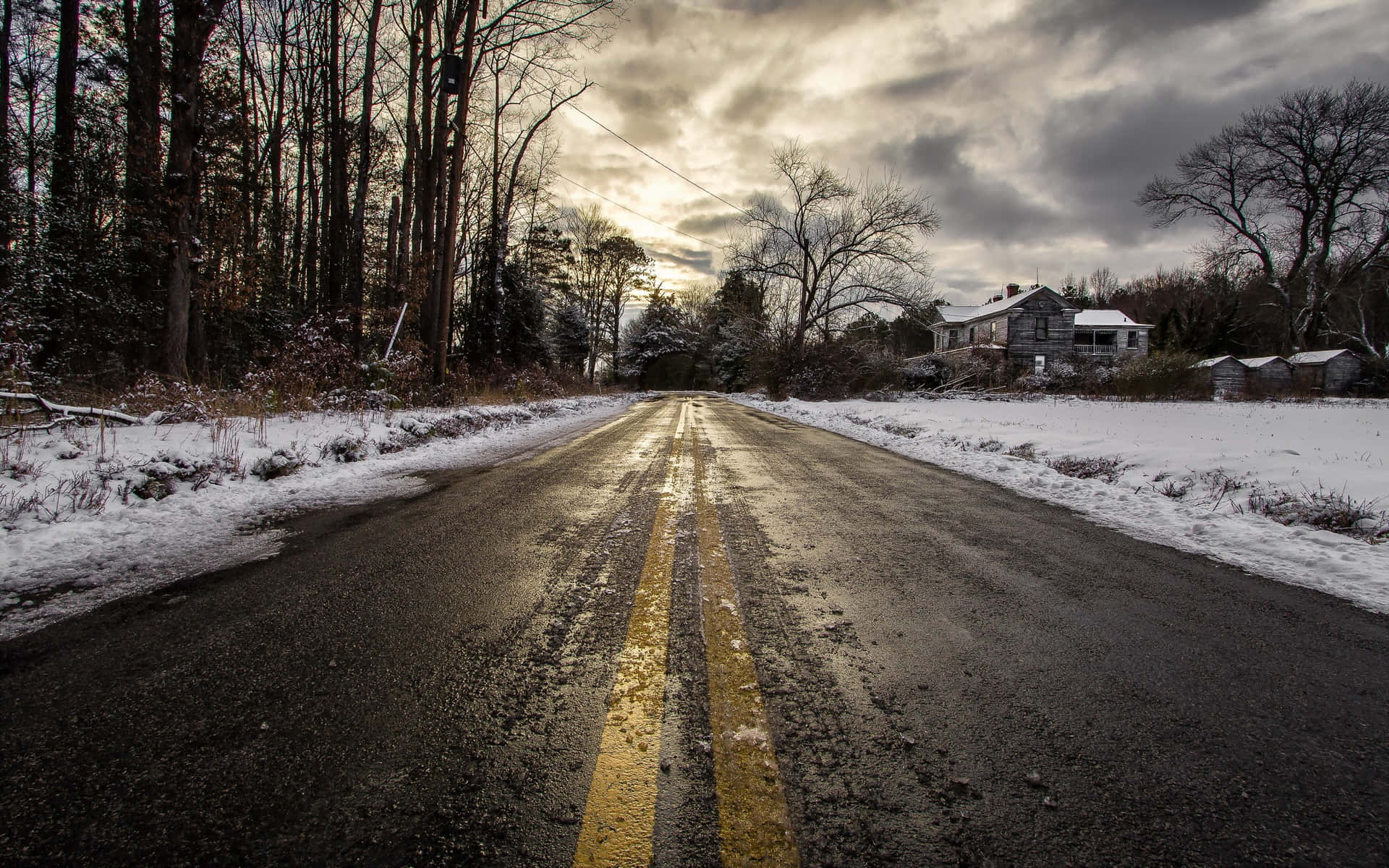 A Serene Snowy Road Amidst A Winter Wonderland Wallpaper
