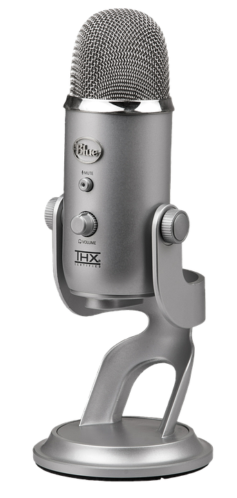 Professional U S B Microphone PNG — A sleek silver Blue Yeti microphone with mesh grille and control knobs stands on a matching stand against a black background.