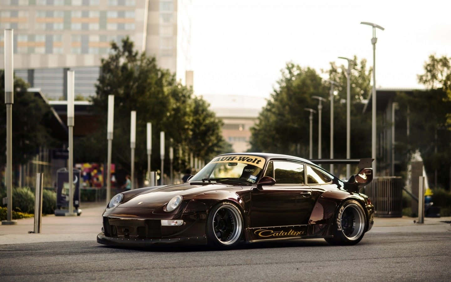 A Silver Porsche 930 Flaunting Its Timeless Beauty Against An Urban Backdrop Wallpaper