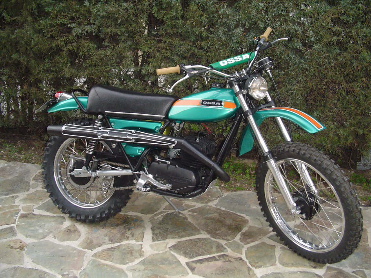 A Spectacular Shot Of Vintage Ossa Motorcycle Parked In The Great Outdoors Wallpaper