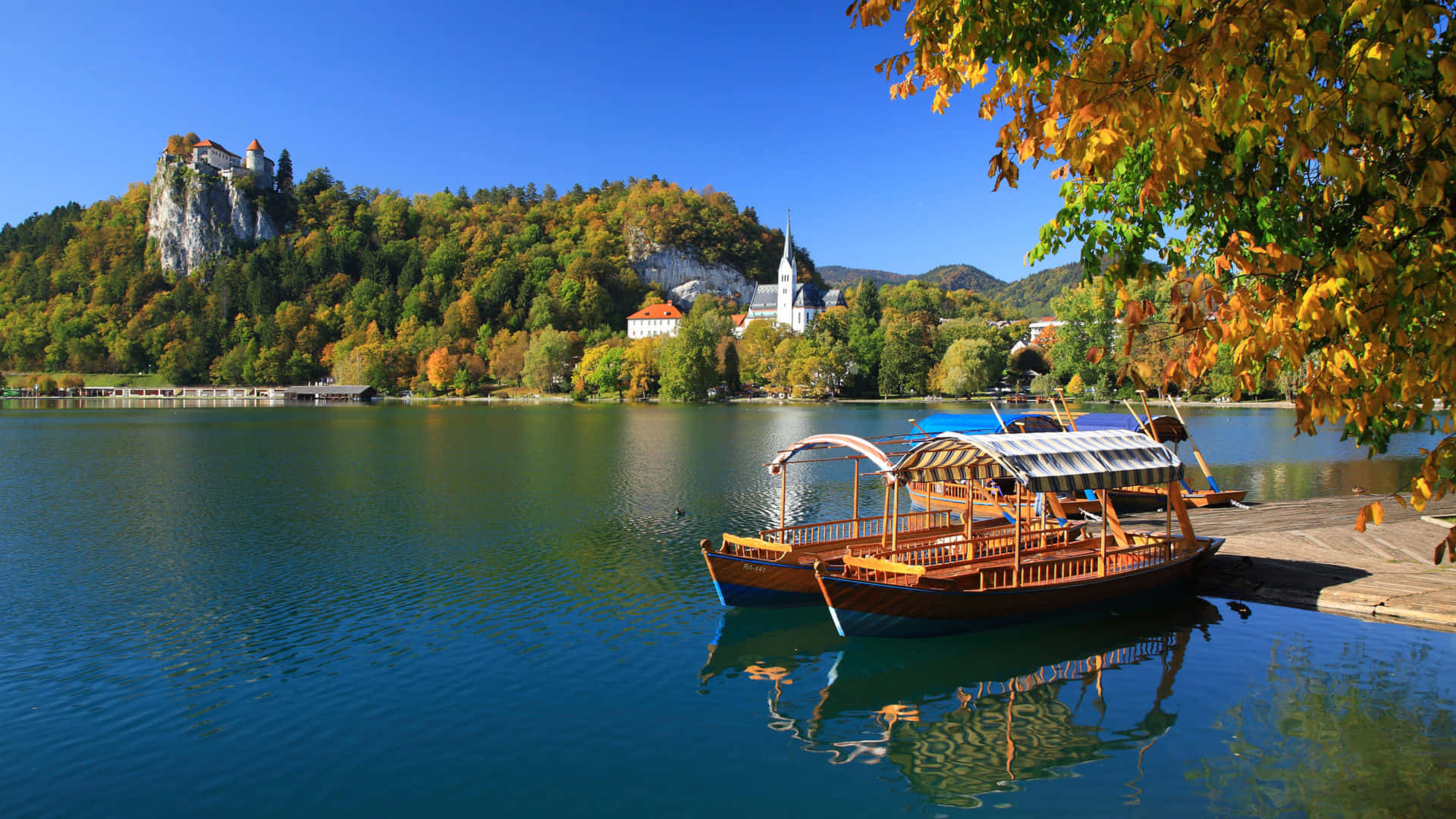 A Tour Boat Docked At Lake Bled Wallpaper