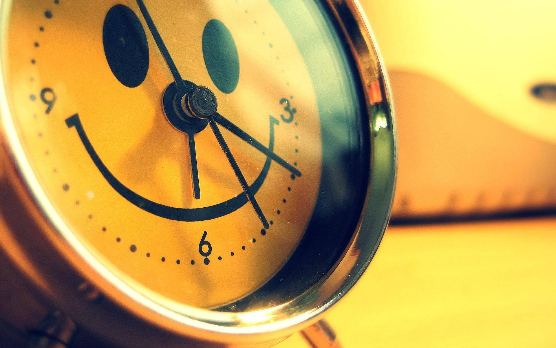 A Yellow Smiley Face Clock With A Cute Smile Wallpaper