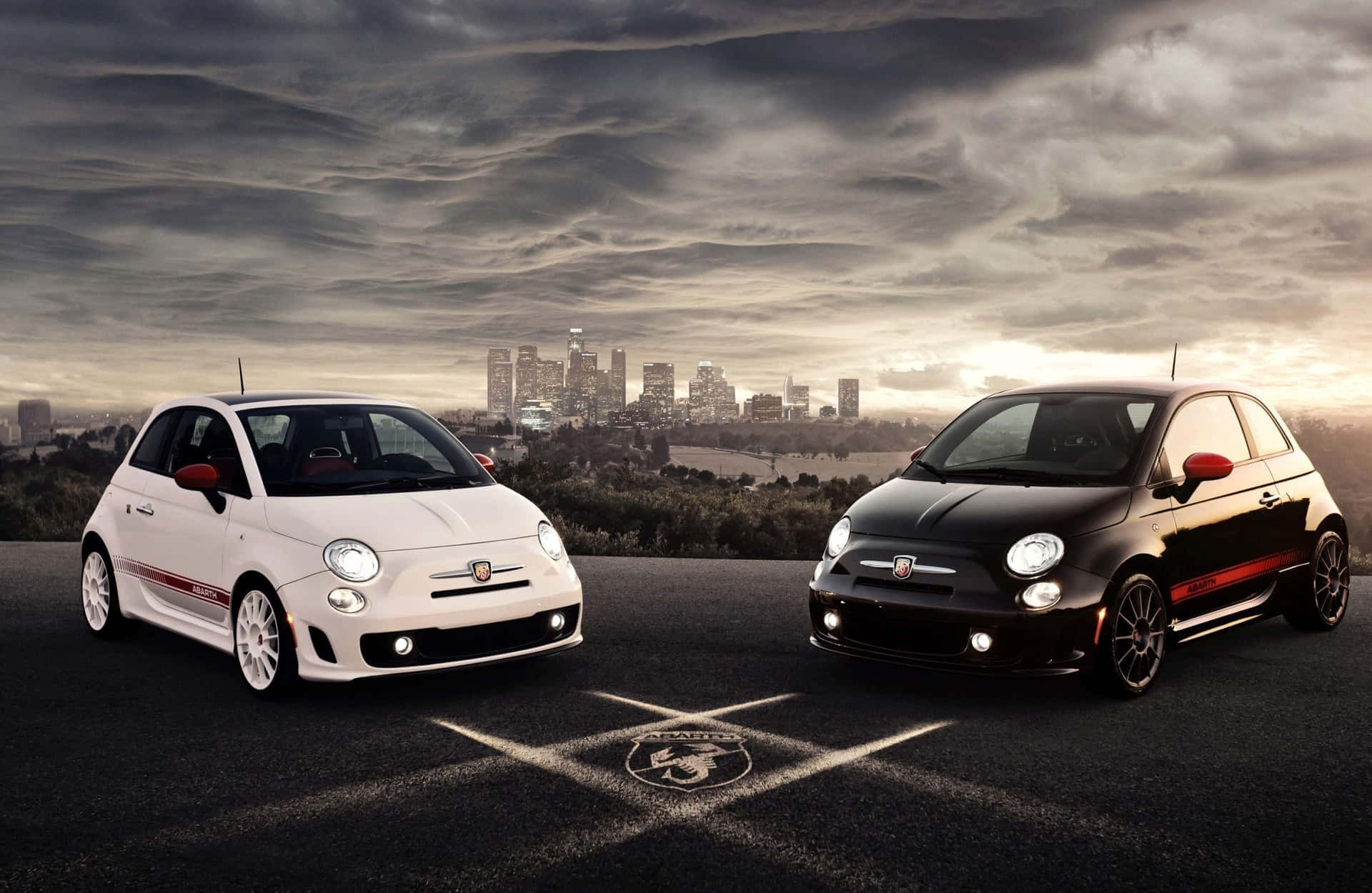 A sleek Abarth car on the road with the sun setting behind it Wallpaper