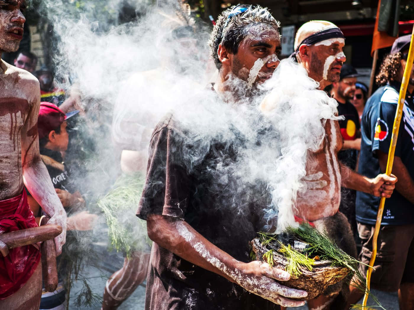 A Group Of People With Paint On Their Faces And Smoke