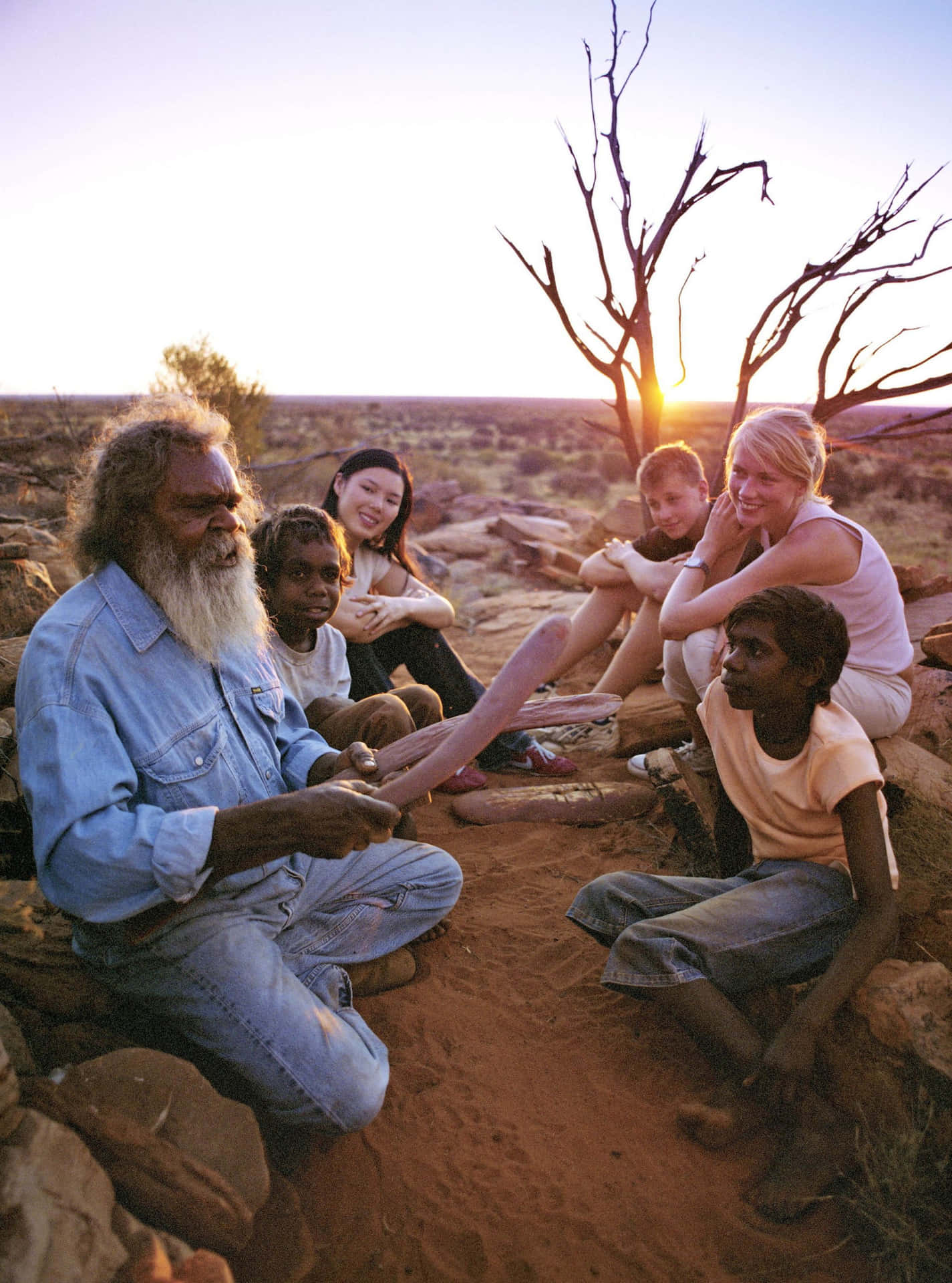 A Group Of People Sitting On The Ground