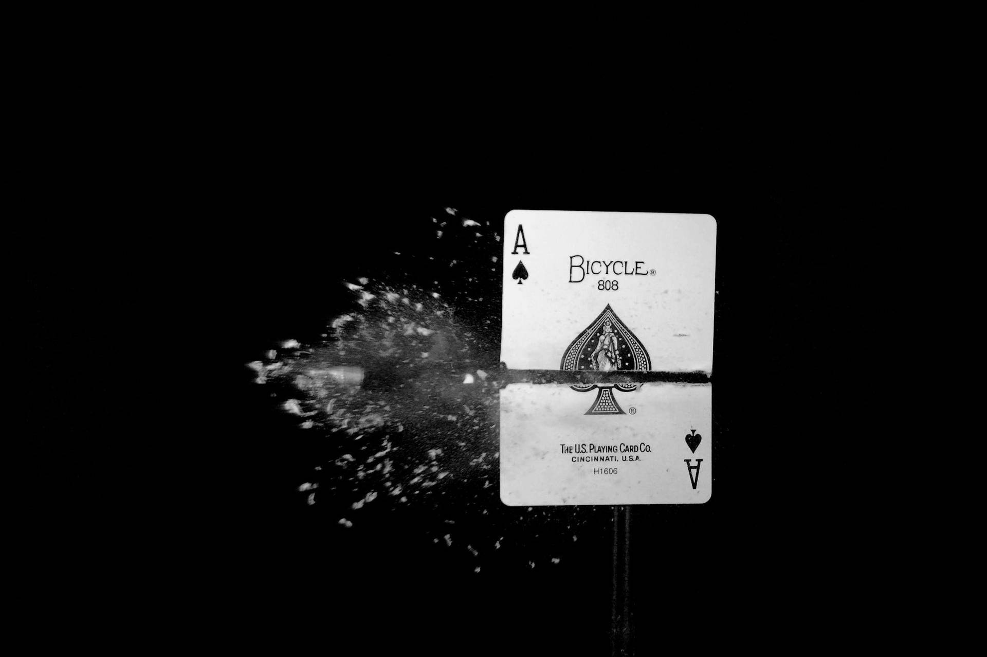 A Black And White Photo Of A Playing Card With A Splash Of Water Wallpaper
