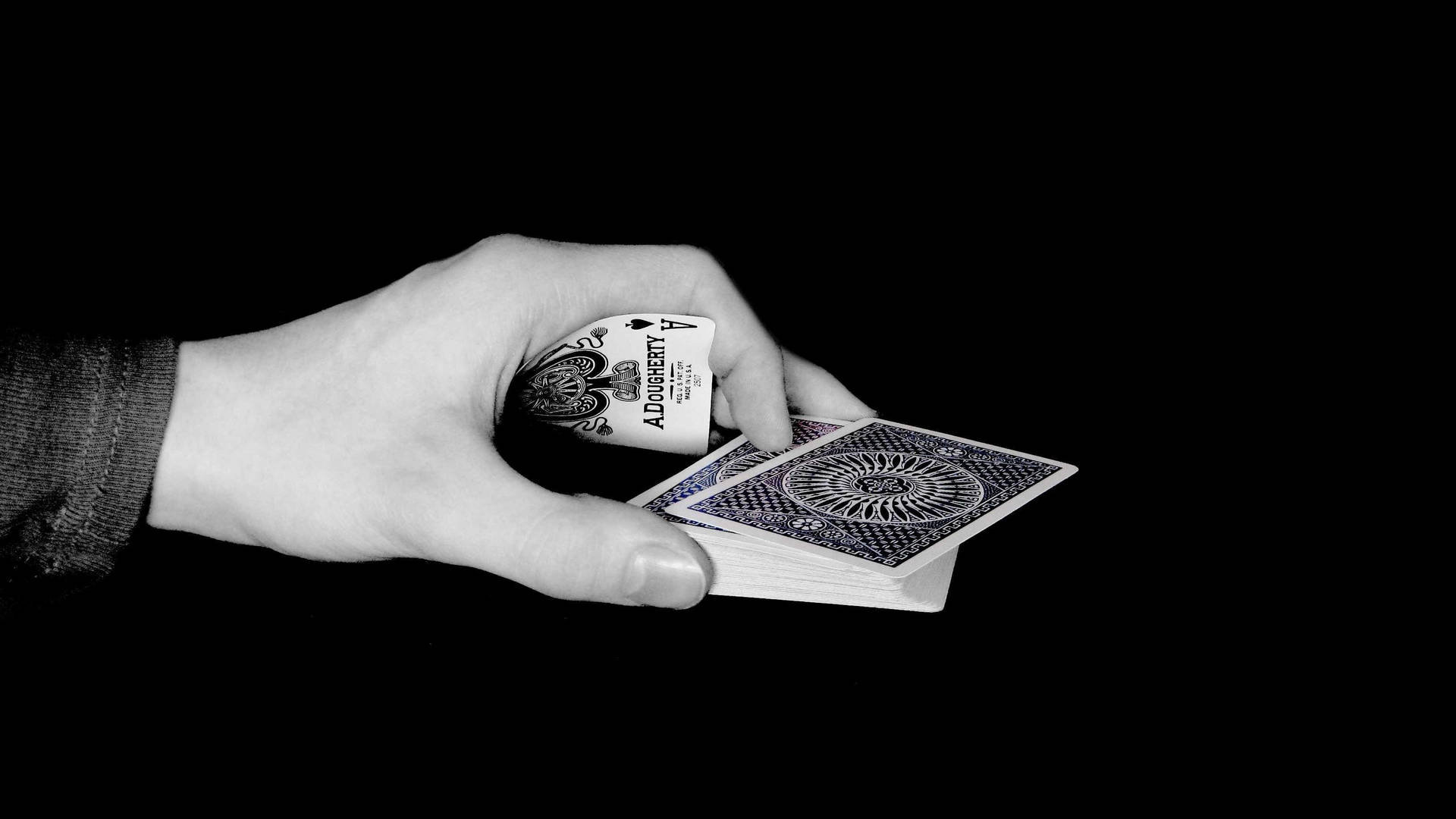 En hånd, der holder et kortspil med sort og hvid Wallpaper