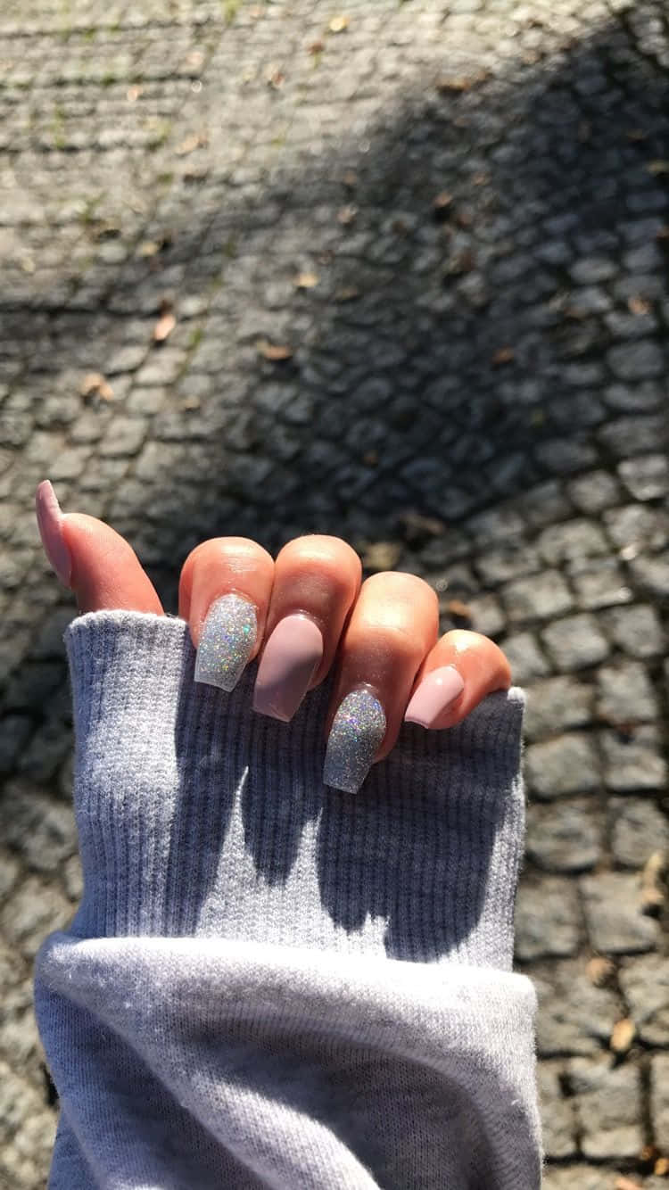A Woman's Hand Holding A Sweater And Nails Wallpaper
