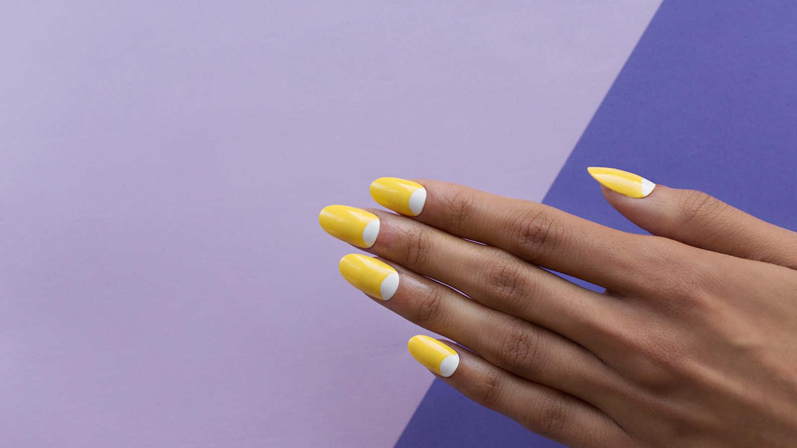A Woman's Hand With Yellow And Purple Nails Wallpaper