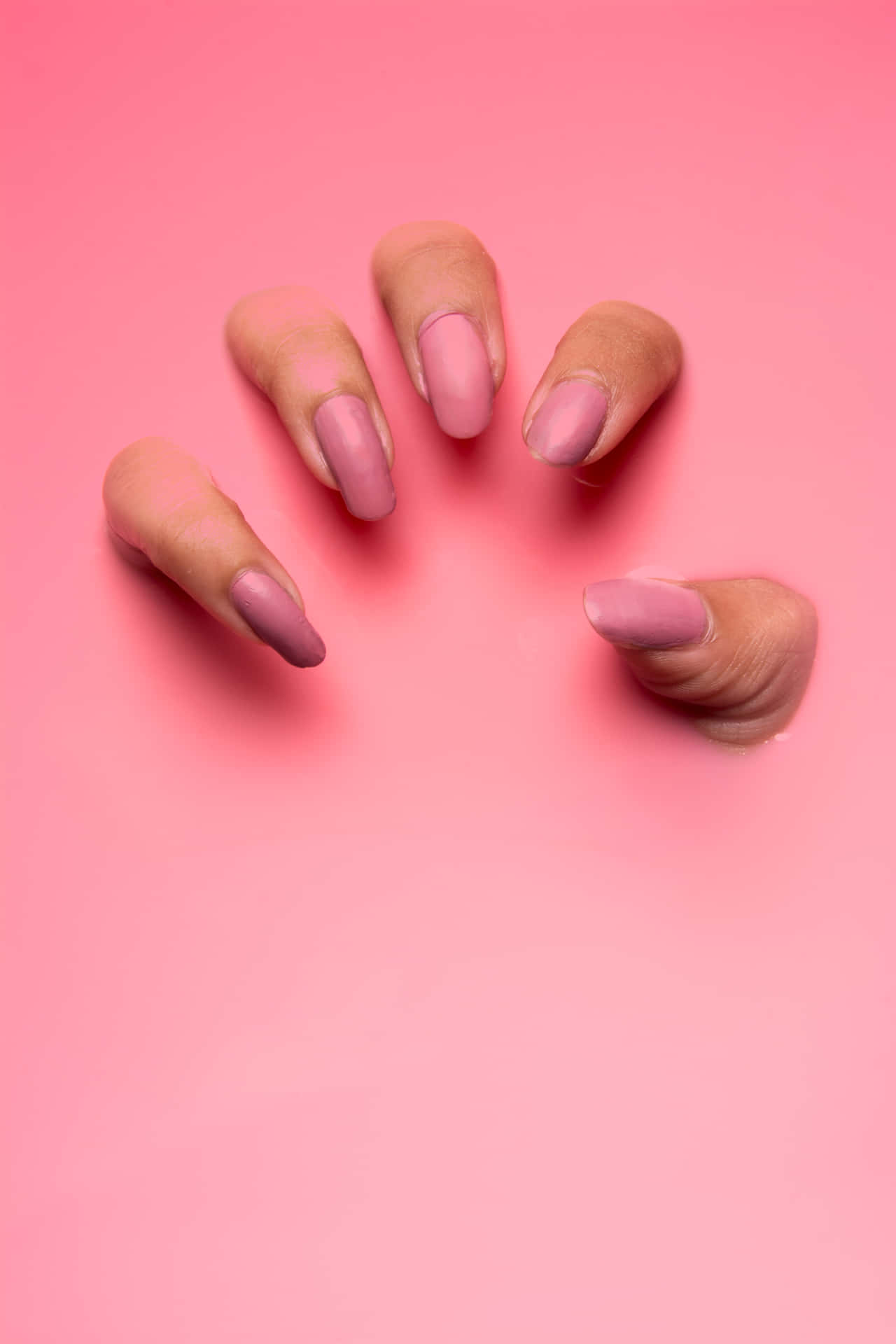 A Woman's Pink Nails Are Shown On A Pink Background Wallpaper