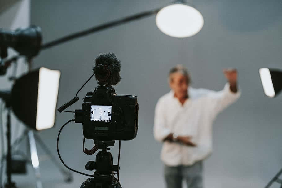 A Man Is Standing In Front Of A Camera In A Studio Wallpaper