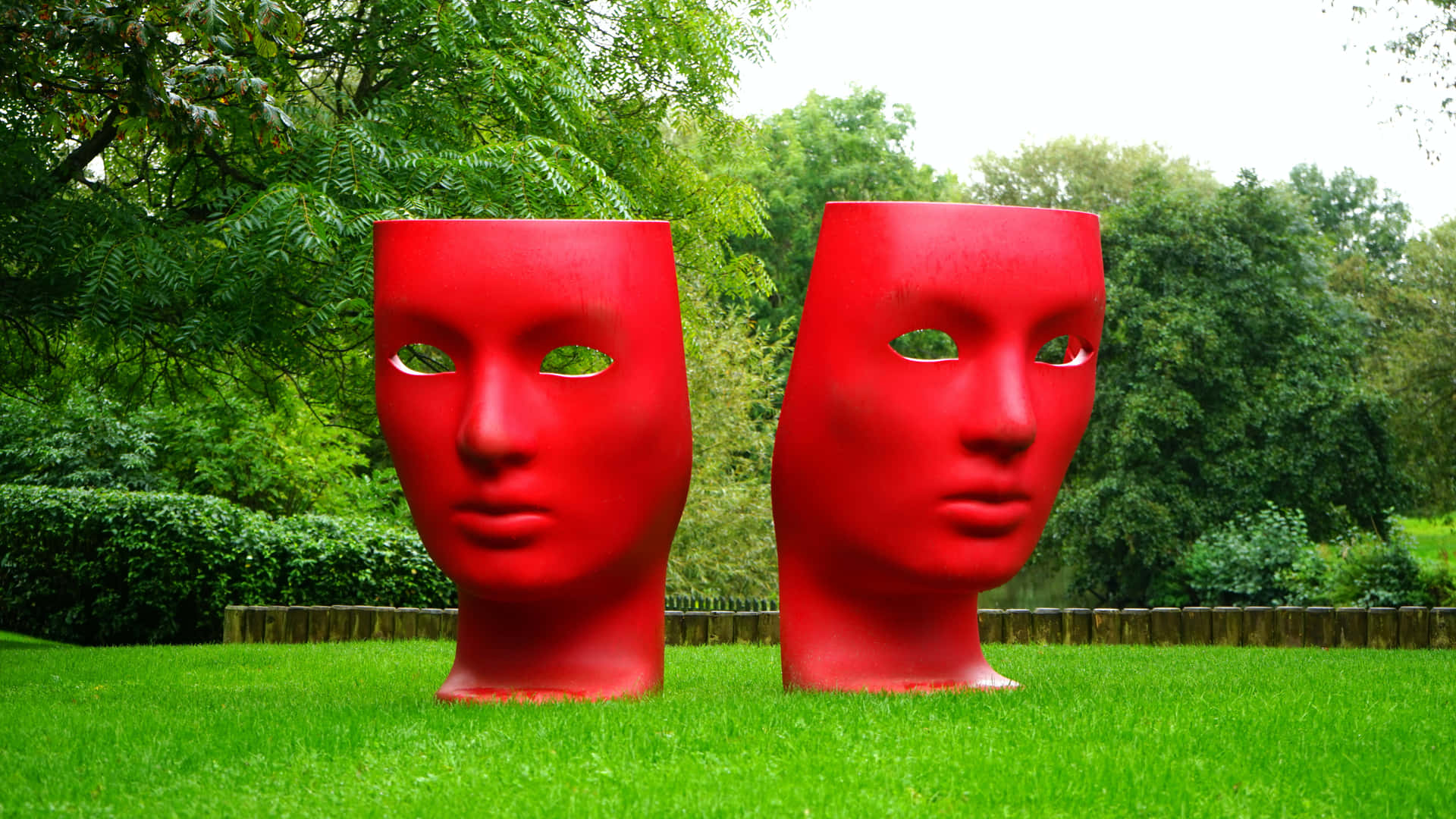 Two Red Sculptures In The Grass Wallpaper
