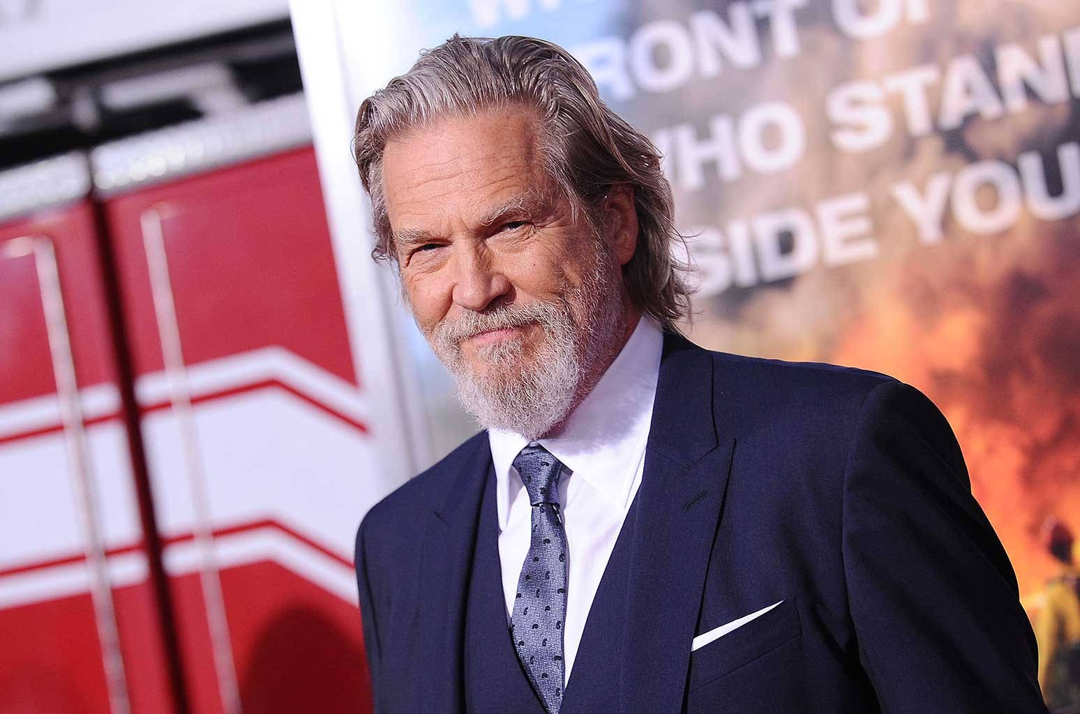 Jeff Bridges i mørkeblåt jakkesæt mod et hvidt baggrund Wallpaper