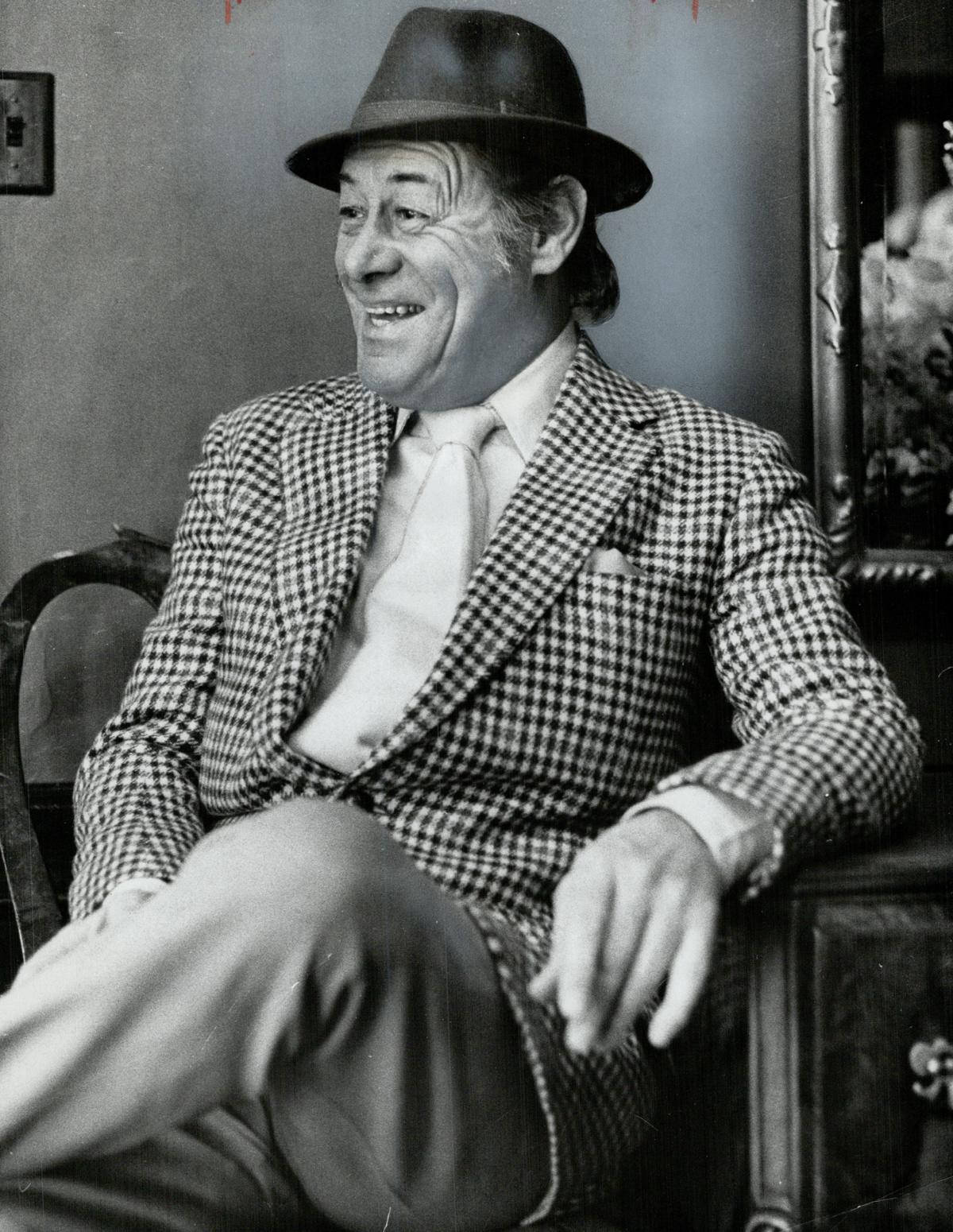 Rex Harrison griner i sin stol Wallpaper