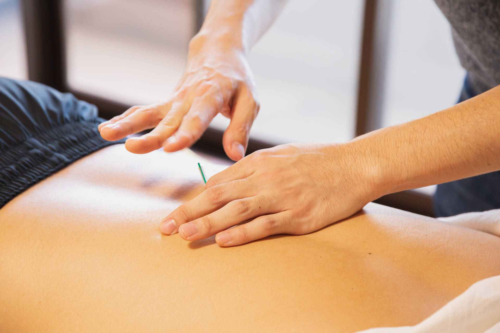 Akupunktør indsætter nål gennem ryg hud Wallpaper