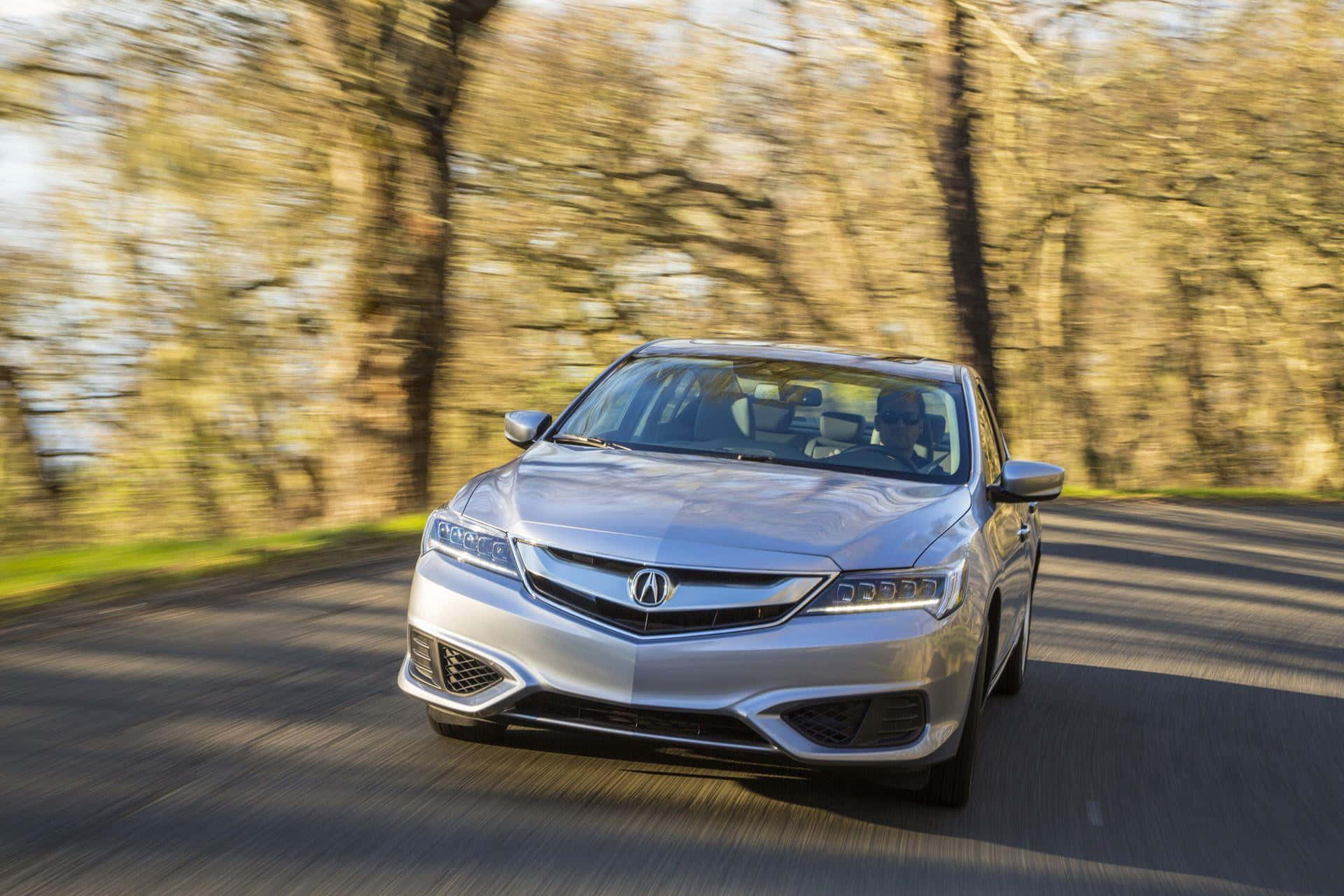 Sleek Acura ILX cruising on an open road Wallpaper