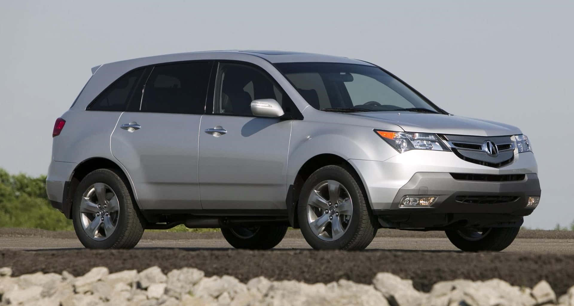 Caption: A Sleek and Stylish Acura MDX on the Road Wallpaper