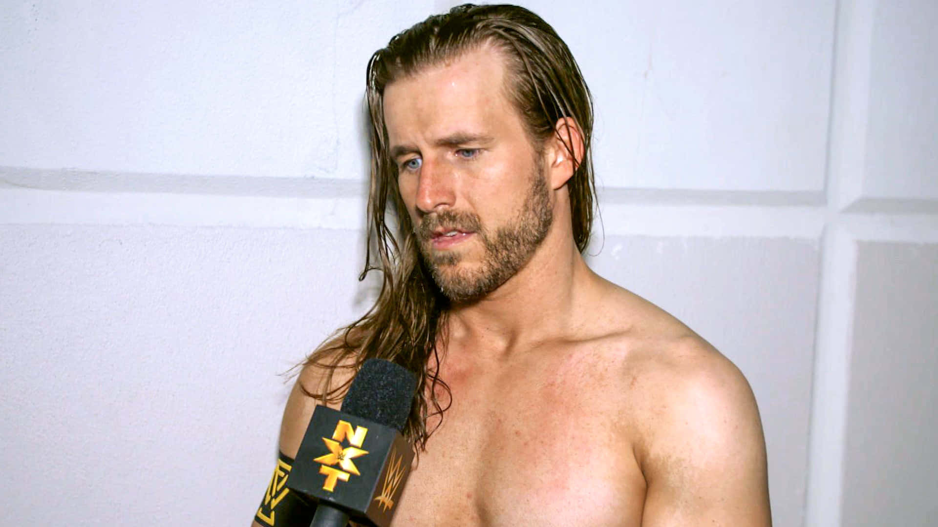 WWE superstar Adam Cole engaging in a backstage interview. Wallpaper