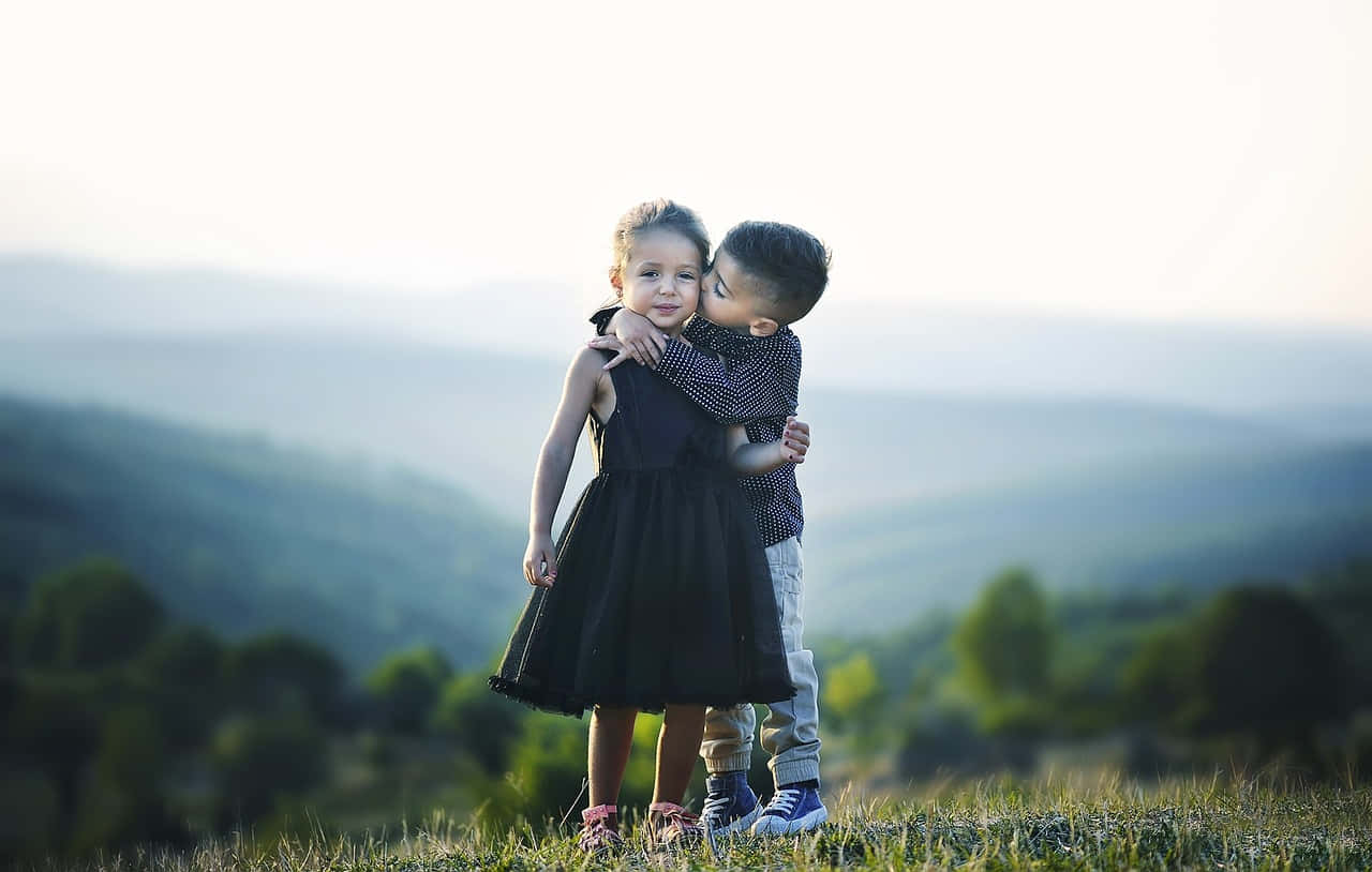Adorable Photo Of A Tangible Young Boy And A Girl On The Mountain Wallpaper