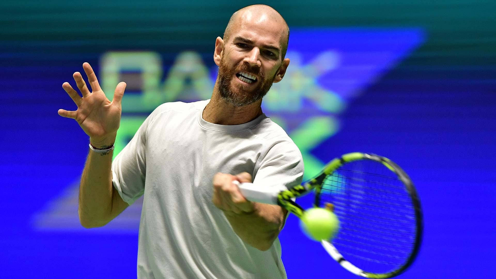 A Man Is Playing Tennis On A Stage Wallpaper