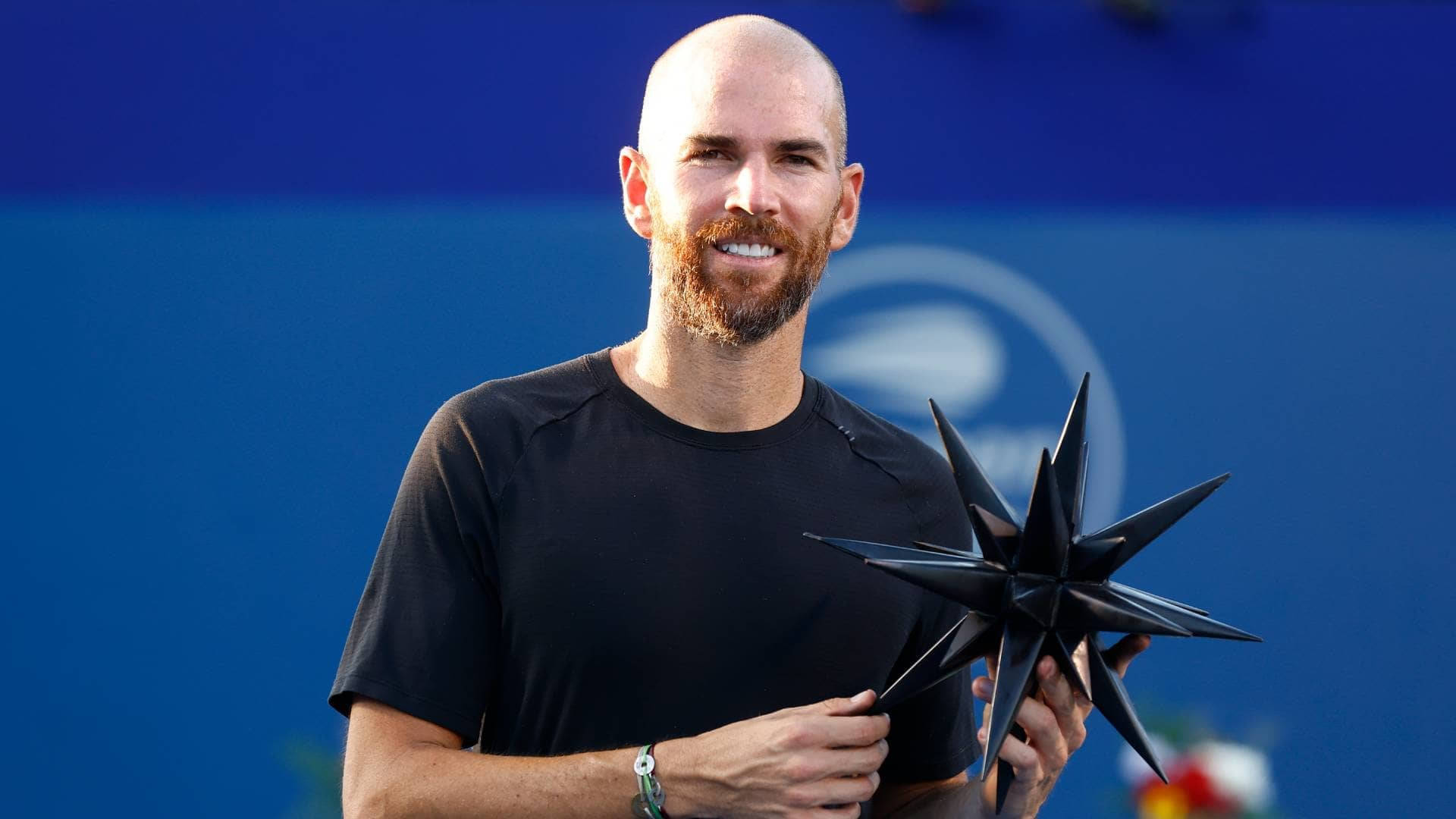 A Man Holding A Star On A Tennis Court Wallpaper