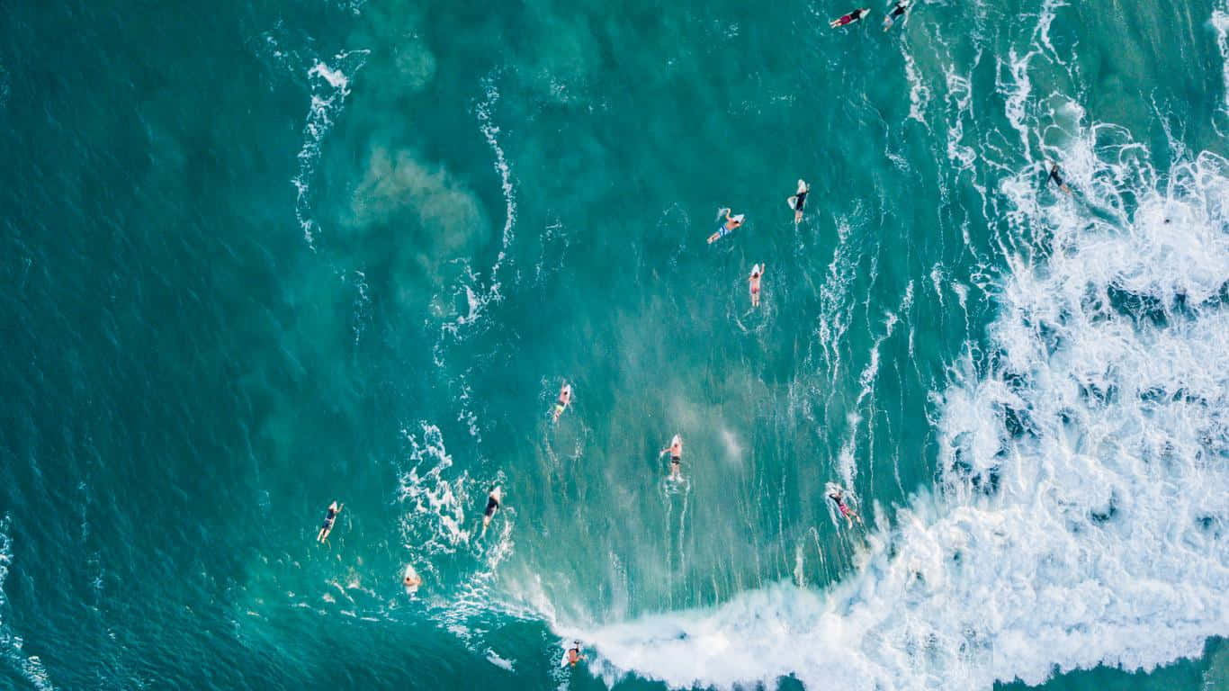 Aerial Surfers Riding Waves Wallpaper