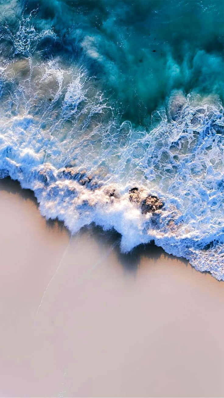 Aerial_ View_ Crystal_ Clear_ Waves_ Crashing_ Shoreline.jpg Wallpaper
