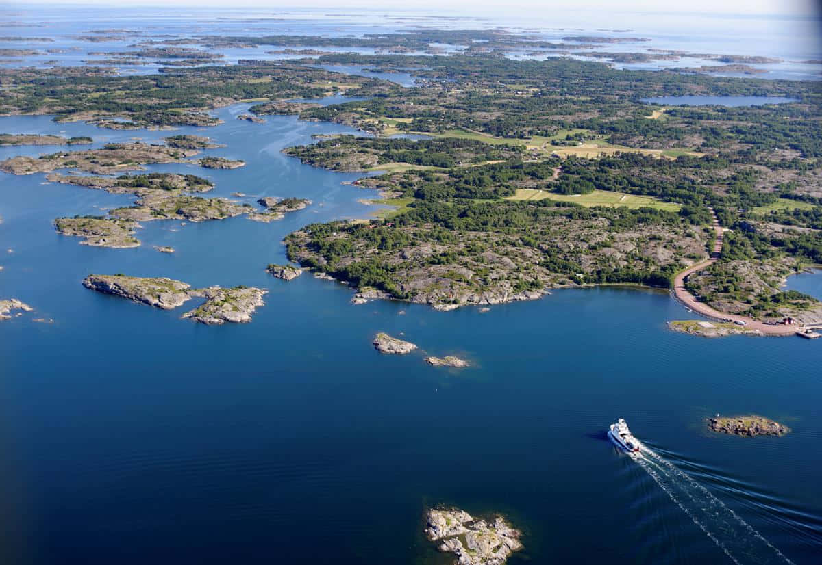 Aerial_ View_of_ Coastal_ Archipelago_with_ Boat Wallpaper