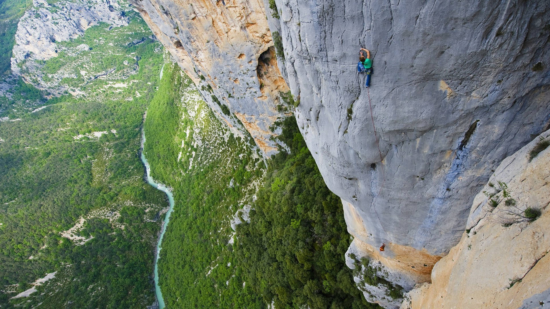 Aerial View Of Man Rock Climbing Wallpaper