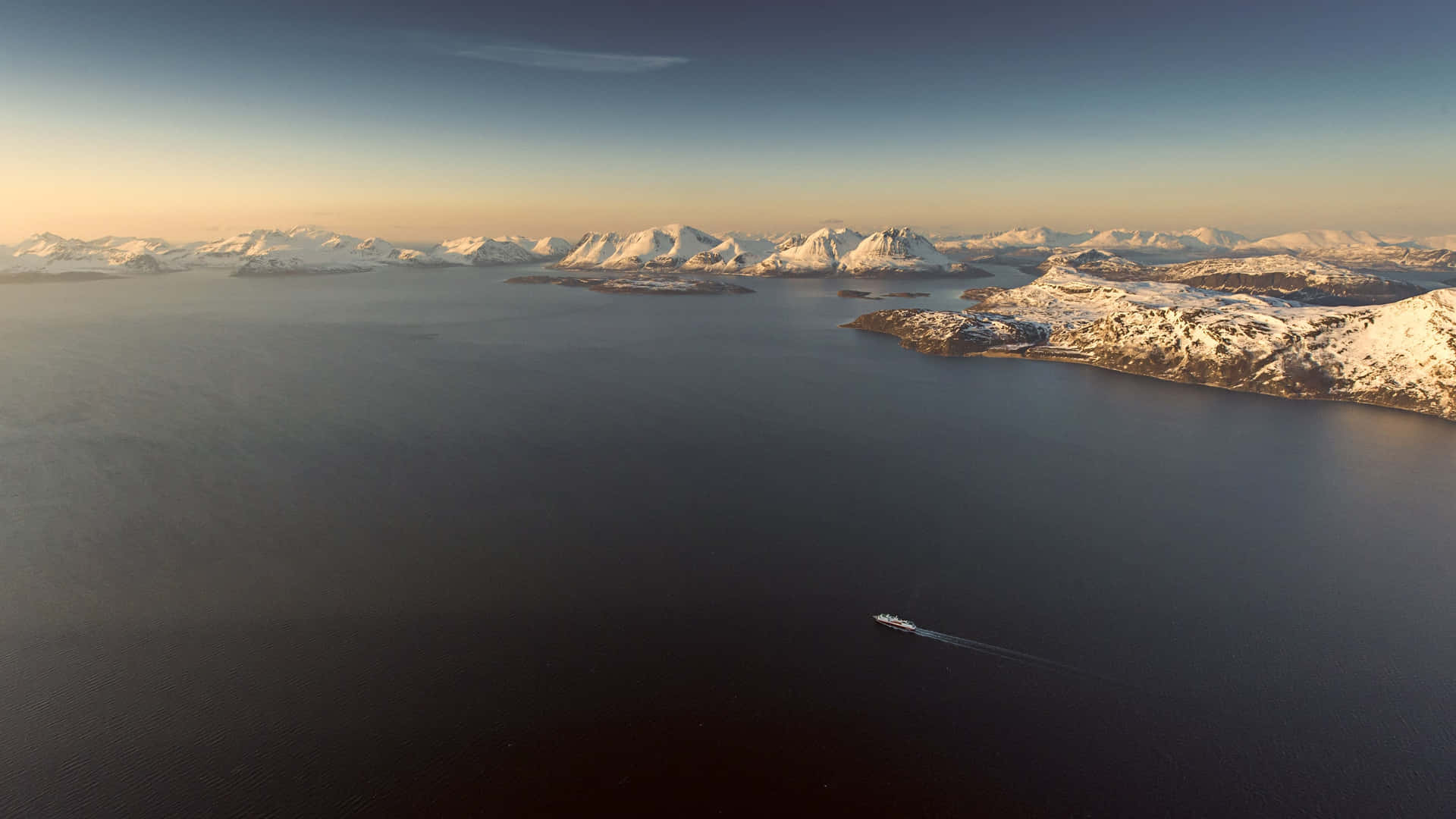 Aerial_ View_of_ Snowy_ Fjord_with_ Boat Wallpaper