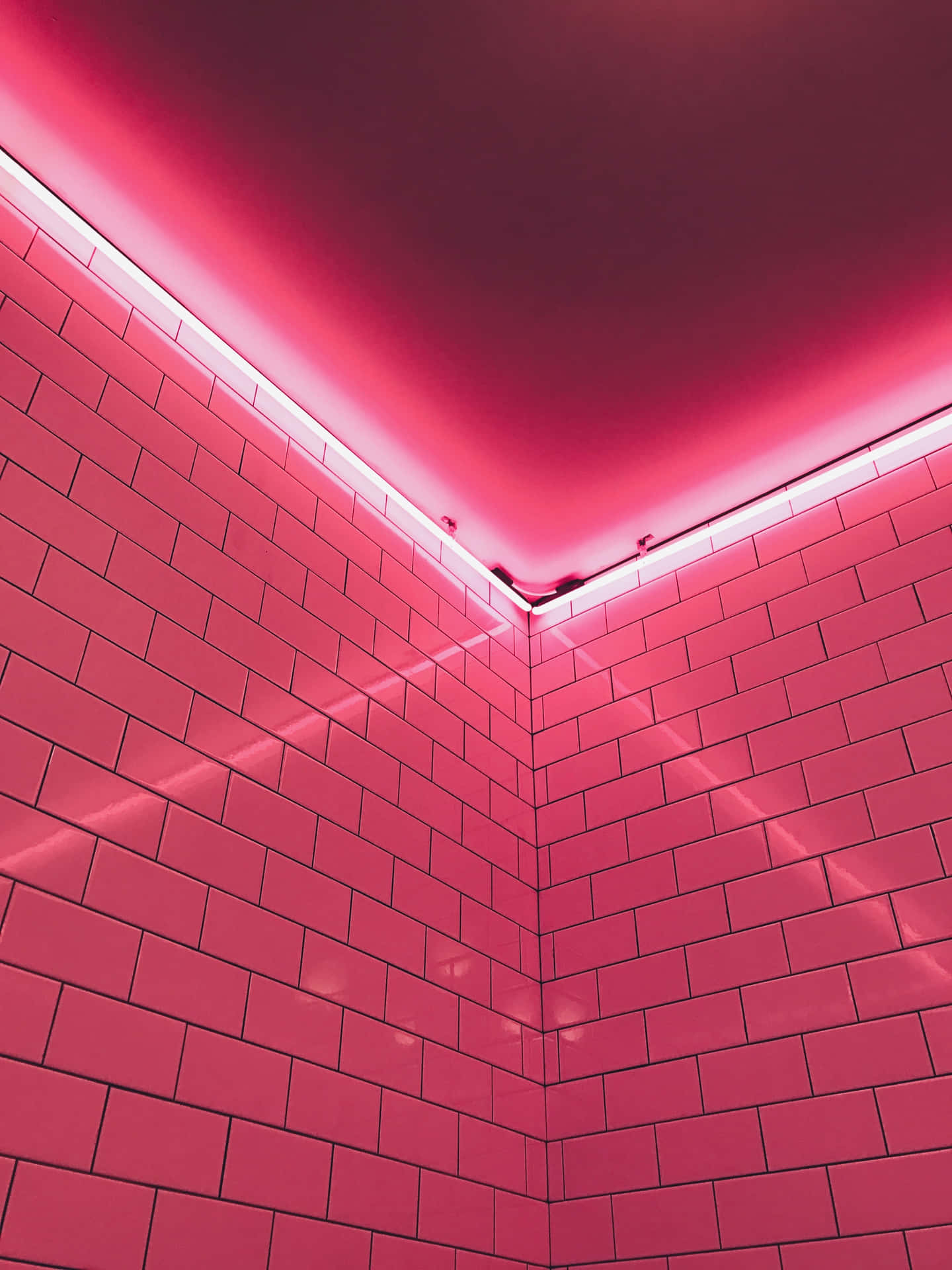 A Pink Tiled Bathroom With A Pink Light Wallpaper