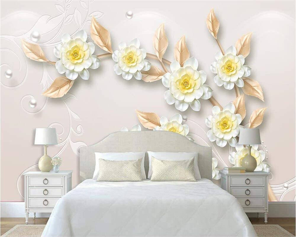 A Bedroom With A White Bed And White Flowers Wallpaper