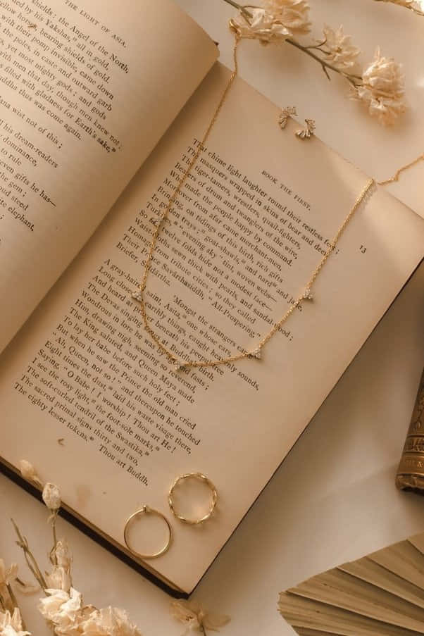 A Book With A Necklace And Ring On It