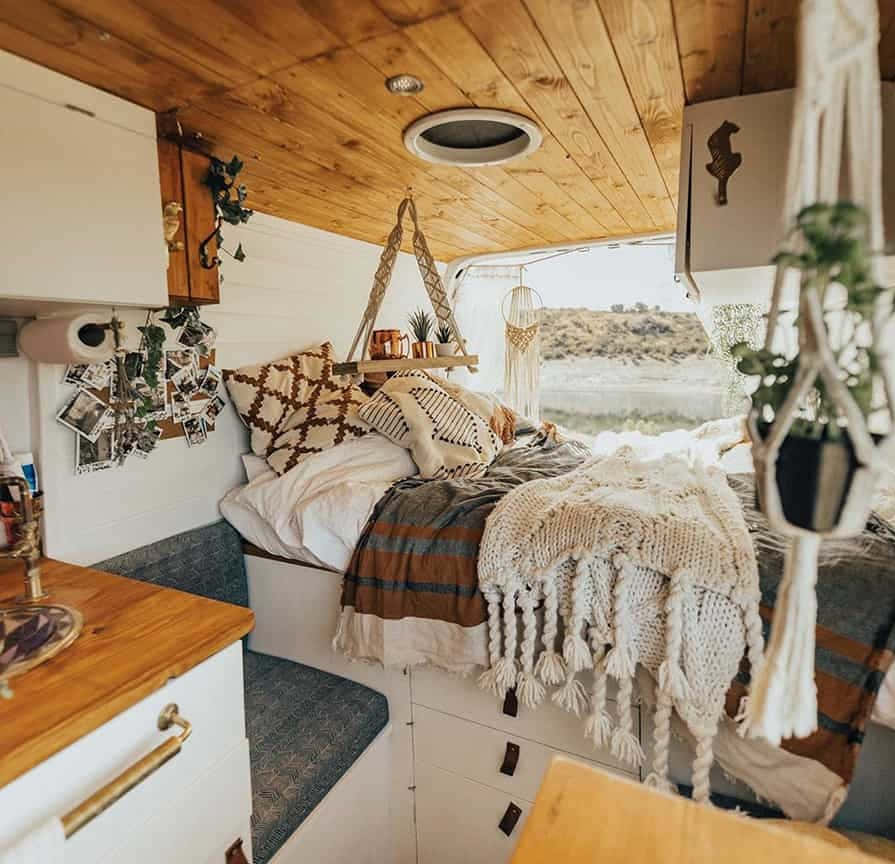 A Small Camper With A Bed And A Bedside Table