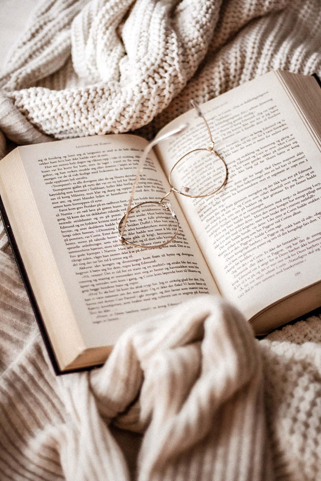 A Book And Glasses On A Blanket