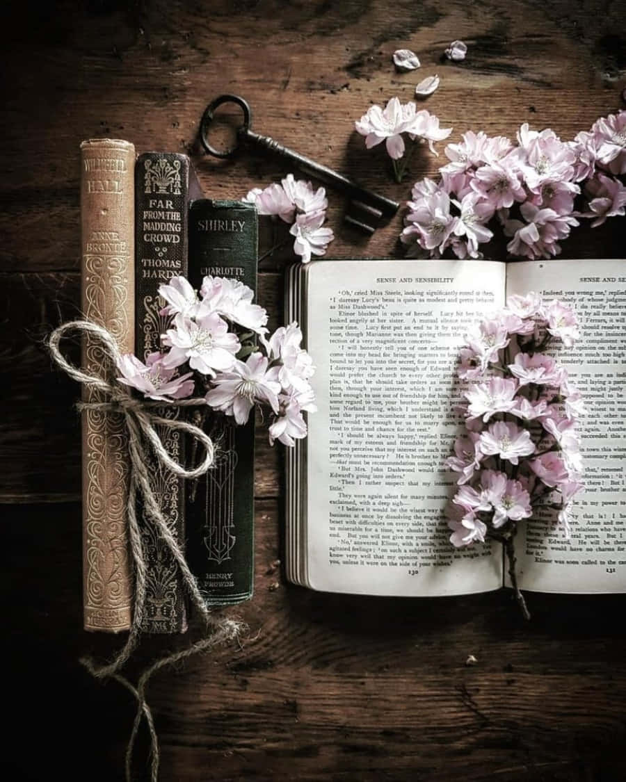 A Book With Flowers And Keys On A Wooden Table