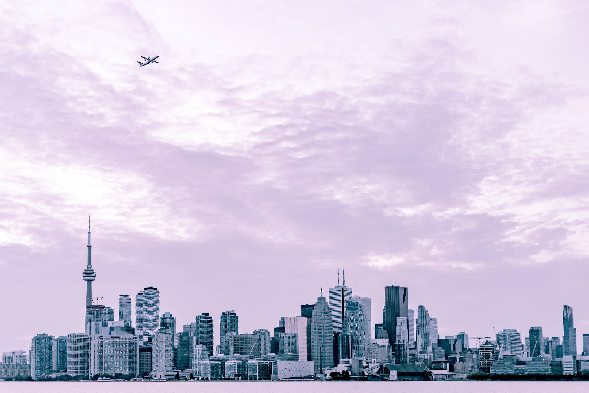Aesthetic photography wallpaper of city scape under a flying plane. 
