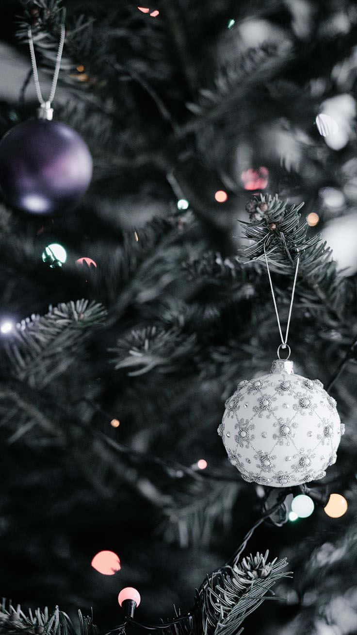 A Christmas Tree With Ornaments Hanging From It Wallpaper