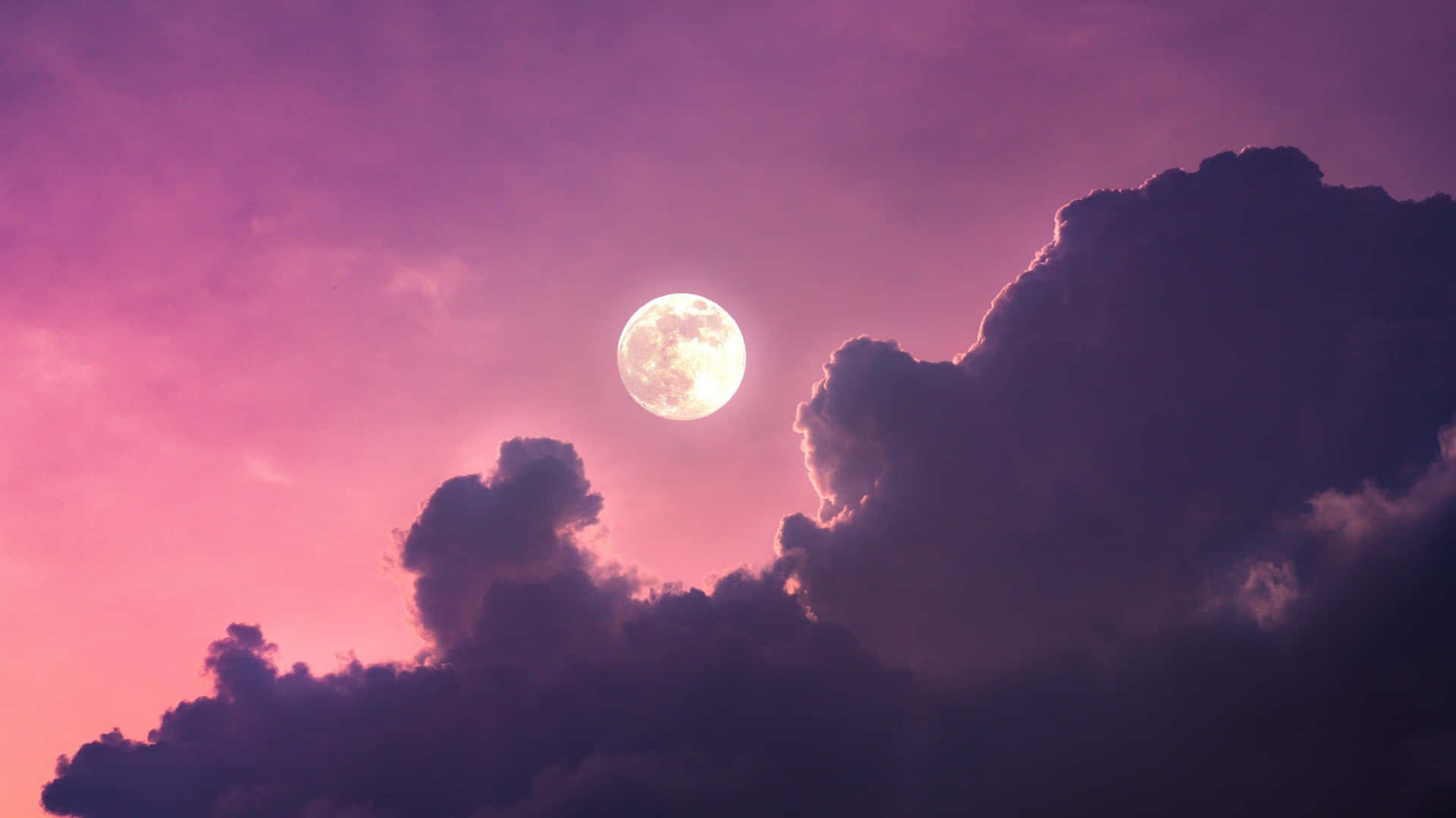 A Full Moon Rising Above A Purple Sky