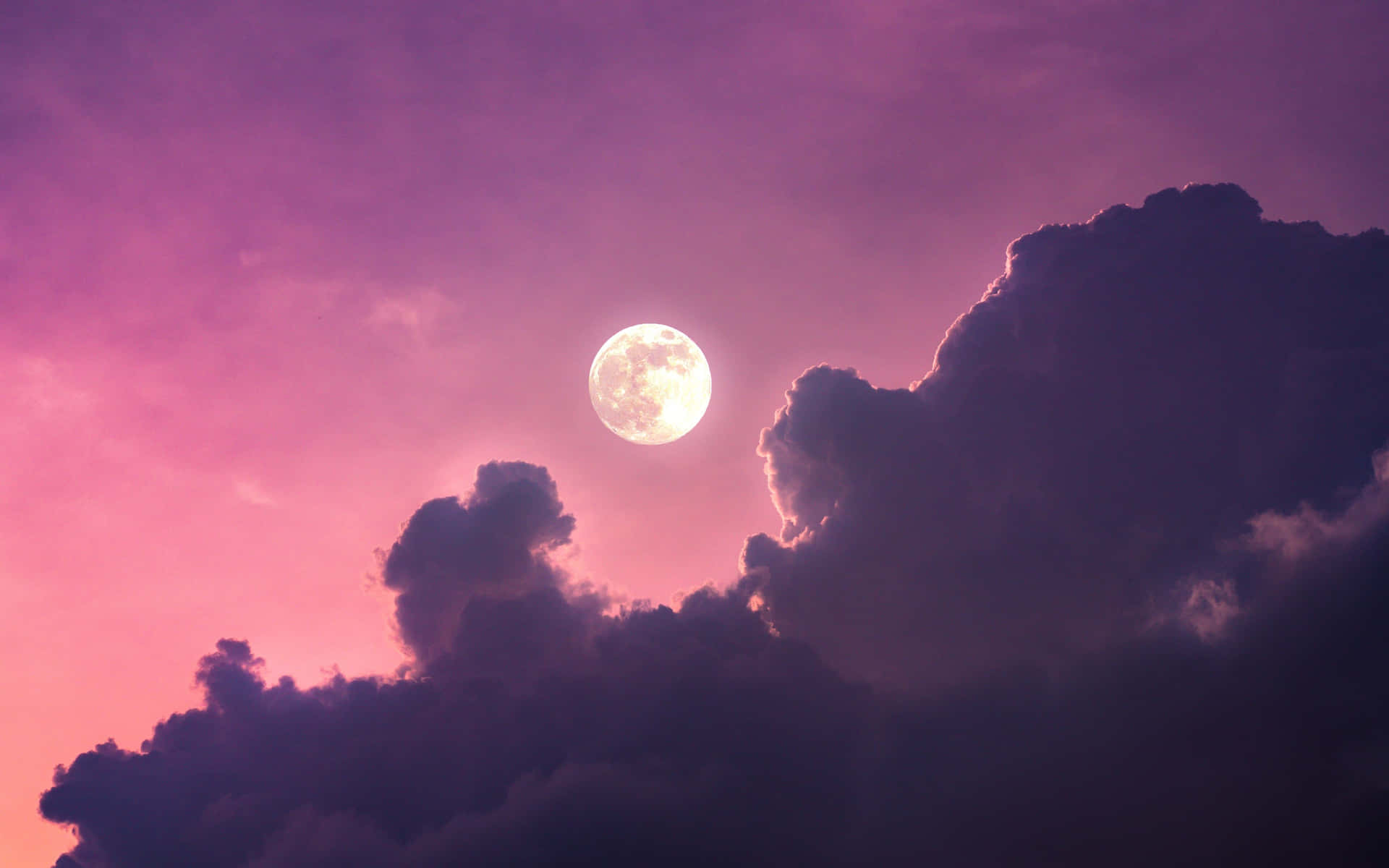 A Moon Is Seen Through A Purple Cloudy Sky Wallpaper