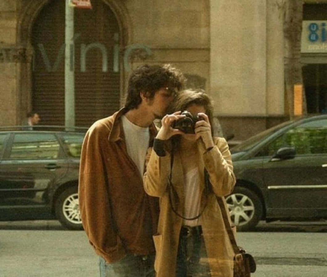 A Couple Taking A Picture Of Each Other On The Street
