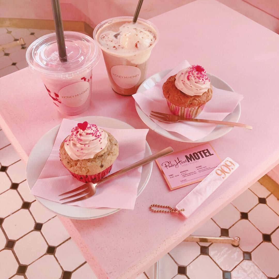 A Pink Table With Cupcakes And Drinks On It