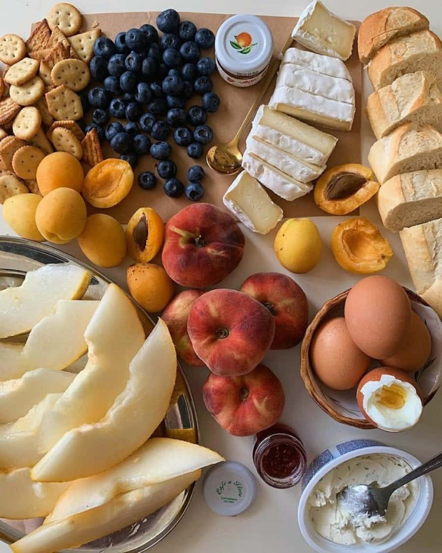 A Table With A Variety Of Fruit, Bread, Cheese And Crackers